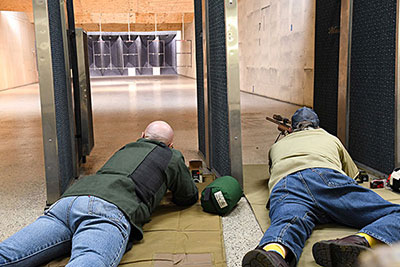 2 people shooting at an indoor range prone